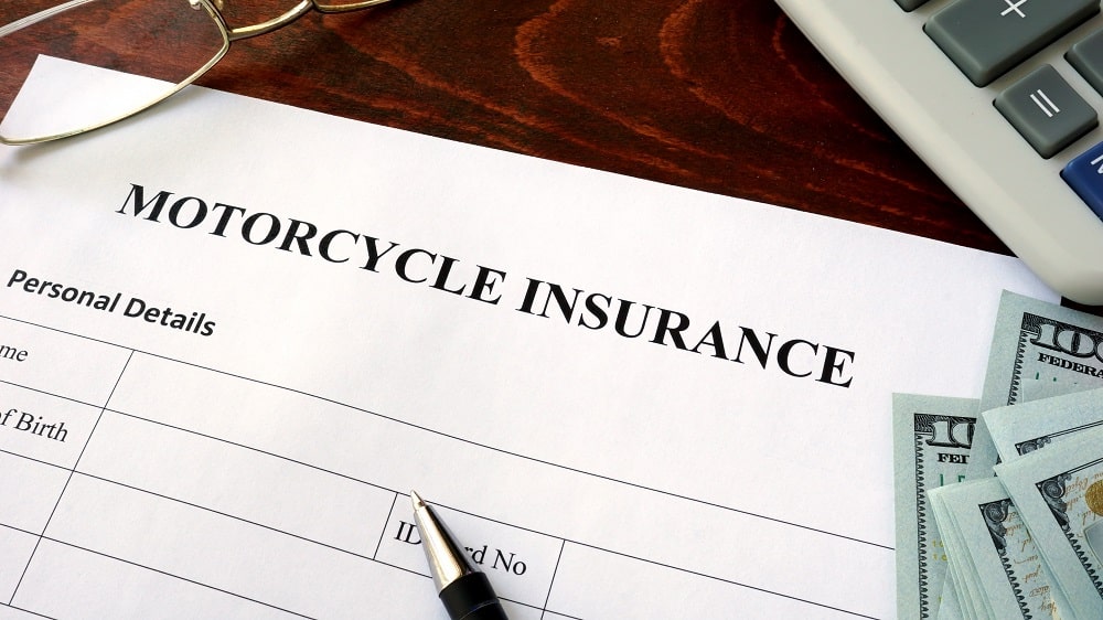 Motorcycle,Insurance,Form,And,Dollars,On,The,Table.