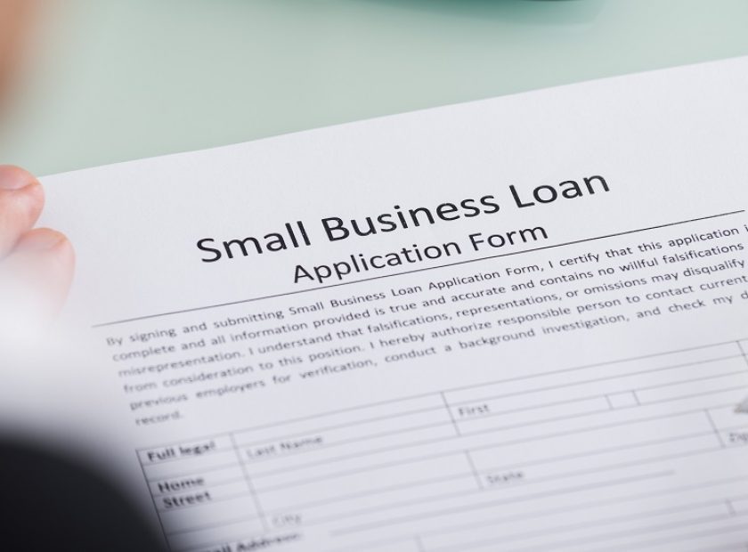 Close-up,Of,Person,Hand,Over,Small,Business,Loan,Application,Form